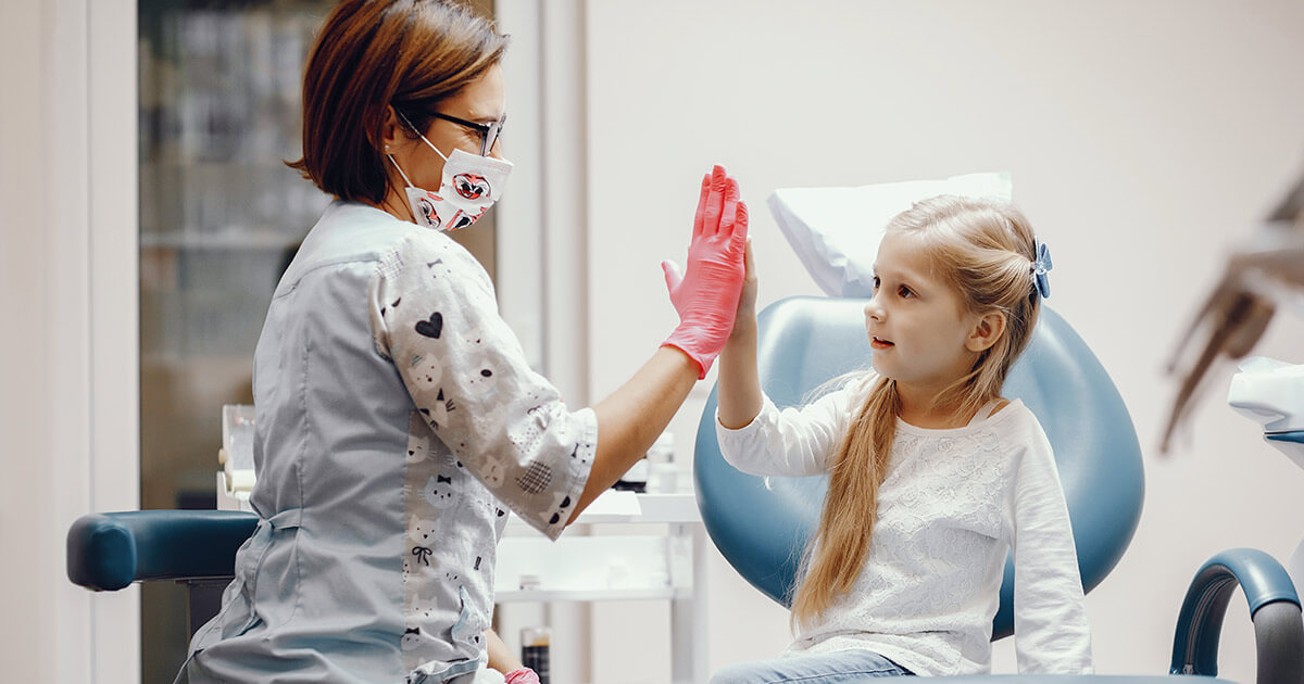 Explicación sobre los dientes separados a una niña paciente